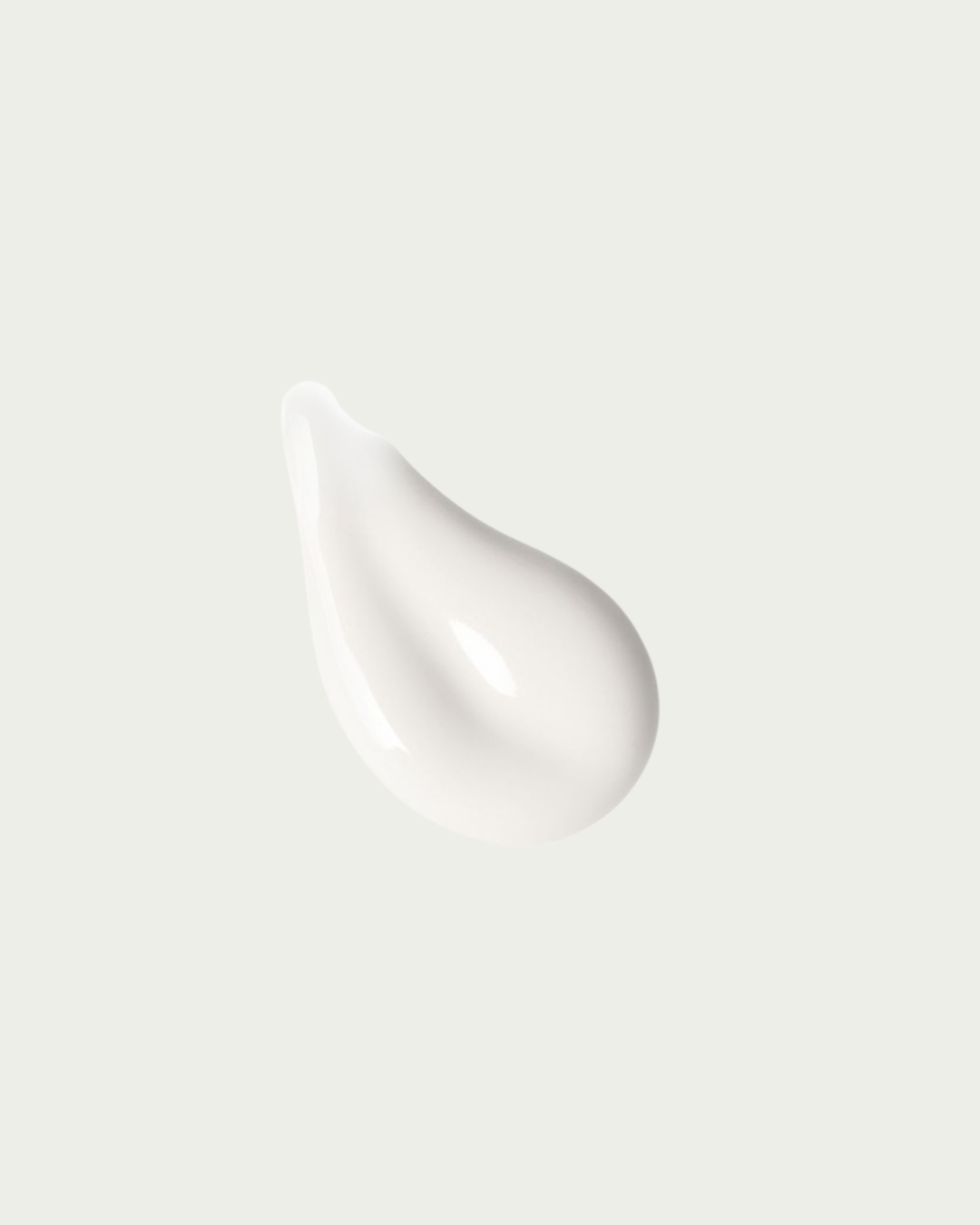 White cream droplet on a light gray background