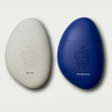 Two pebble-shaped skincare products, one gray and one blue, with 'The Rising' branding on a light gray background.