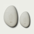 Two pebble-shaped sunscreen products with 'The Rising' branding on a light gray background.