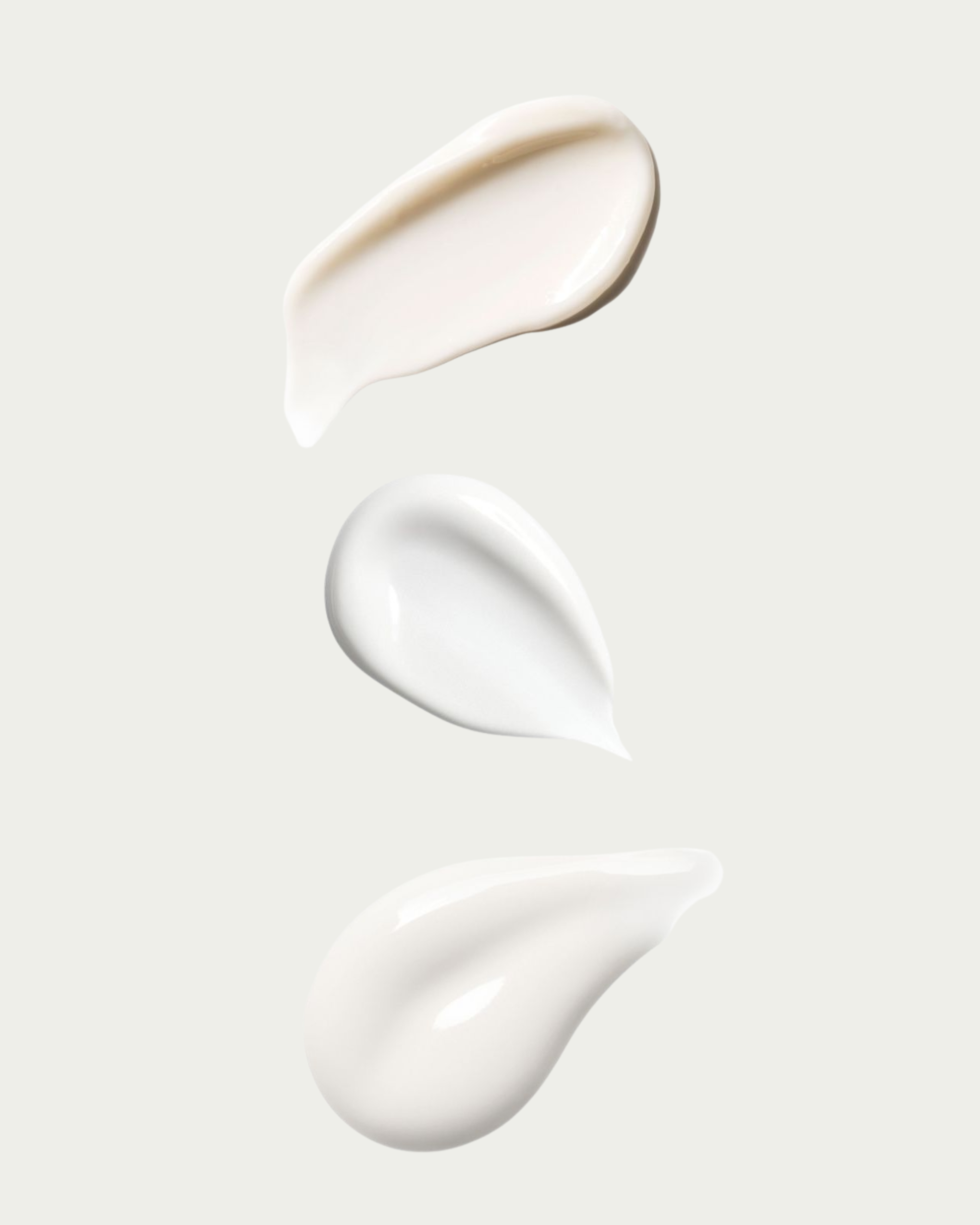 Three texture swatches of white cream on a light gray background
