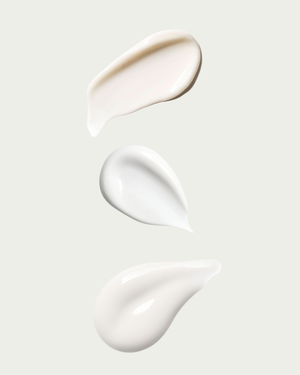 Three texture swatches of white cream on a light gray background